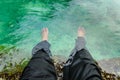 Feet submerged in tropical water of emerald pool in Krabi, Thailand. Selective focus on leg.