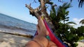 Feet swinging in a hammock on a caribbean tropical beach, POV. Livingston, Guatemala.