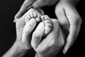 Feet of a tiny newborn. Children& x27;s foot in the hands of mother, father, parents Royalty Free Stock Photo