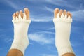 Feet with yoga toe separator socks on sky background