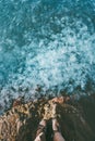 Feet traveler boots standing at the edge above sea full of Jellyfish in water Royalty Free Stock Photo