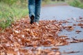 Feet trekking boots hiking through fall foliage. Traveler alone outdoor wild nature. Woman walking away on the road Royalty Free Stock Photo