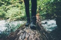 Feet trekking boots Traveler alone crossing over river