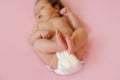 Feet of a two months old baby wearing diapers lying on the bed at home Royalty Free Stock Photo