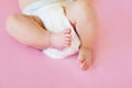 Feet of a two months old baby wearing diapers lying on the bed at home Royalty Free Stock Photo