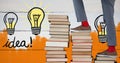 Feet walking up book stairs with colorful light bulb graphics and orange painted wall