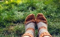 Feet in warm woolen socks. Knitted wool socks. Feet in socks on the background of green grass. Autumn concept, travel Royalty Free Stock Photo