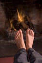 Feet warming at a fireplace