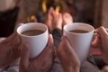 Feet warming at fireplace with coffee