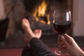 Feet warming at fireplace with wine