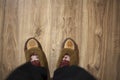 Feet wearing Christmas socks on wood floor. Happy family at home. Xmas holidays concept Royalty Free Stock Photo