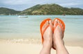 Feet Wearing Orange Flip Flop on a Beach 1