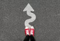 Feet and white arrow sign go straight on road background. Top view of woman. Forward movement and motivation idea concept. Selfie