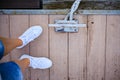 feet in white sneakers are standing on the pier top view. vaarwater Royalty Free Stock Photo