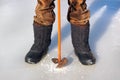 Feet in winter boots and ice drill Royalty Free Stock Photo