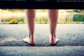 Feet of a woman sitting on a bench near the lake or pond Royalty Free Stock Photo