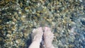 Feet of woman treading water in a natural pool