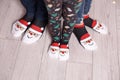 Feet in wool socks near fireplace in winter. Closeup image of family in warm knitted socks lying next to fireplace