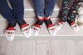 Feet in wool socks near fireplace in winter. Closeup image of family in warm knitted socks lying next to fireplace Royalty Free Stock Photo