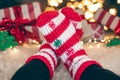 Feet in wool socks near fireplace in winter time, resting at home, close up. Royalty Free Stock Photo