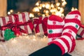 Feet in wool socks near fireplace in winter time, resting at home, close up. Royalty Free Stock Photo