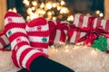 Feet in wool socks near fireplace in winter time, resting at home, close up. Royalty Free Stock Photo