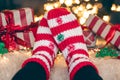 Feet in wool socks near fireplace in winter time, resting at home, close up. Royalty Free Stock Photo