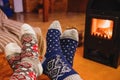 Feet in wool socks warming near fireplace in rustic cabin house. Cozy winter Royalty Free Stock Photo