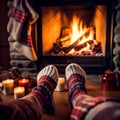 Feet in woolen socks by the Christmas fireplace. A woman in socks warms herself by the fireplace. Female legs in woolen socks by