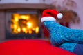 Feet in woollen blue socks and Santa hat . Royalty Free Stock Photo