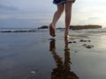 Feet of young woman walking on beach with the shadow of the water reflection background. Royalty Free Stock Photo