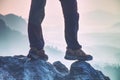 Feets and legs of hiker on peak with hiking trail and misty nature