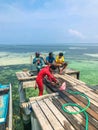 Maldivian local fisherman is cutting fish on the pier