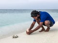 Maldivian man takes a picture of a coral