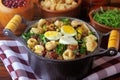 Feijao Tropeiro typical dish of Brazilian cuisine, made with beans, bacon, sausage, collard greens, eggs, on rustic wooden table