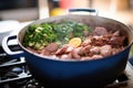 feijoada cooking process with meat and beans in a large pot