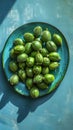 Feijoas on blue ceramic plate, shadow play, AI Generated. Royalty Free Stock Photo