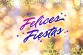 Felices Fiestas. Festive greeting card with happy holiday\'s wishes in Spanish on bright background Royalty Free Stock Photo