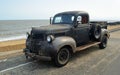 Rusty Classic Dodge Piick up truck parked on seafront promenade.