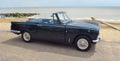 Classic Black Triumph Vitesse open top parked on seafront promenade. Royalty Free Stock Photo