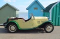 Classic Cream & Green Motor Car Parked on Seafront Promenade parked in front of beach huts.