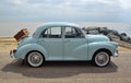 Classic Light Blue Morris Minor with picnic basket parked on seafront promenade. Royalty Free Stock Photo