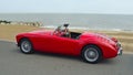 Classic Red MGA Car parked on seafront promenade with sea in background. Royalty Free Stock Photo