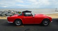 Classic red Triumph TR4  Convertible parked on seafront promenade. Royalty Free Stock Photo