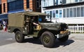 Vintage Small Army Truck being driven along street.