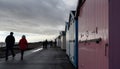 Felixstowe, Suffolk, UK: Beach huts along the promenade with people walking