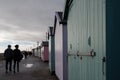 Felixstowe, Suffolk, UK: Beach huts along the promenade with people walking