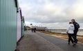 Felixstowe, Suffolk, UK: Beach huts along the promenade with people walking