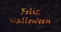 Feliz Halloween text in Spanish dissolving into dust to left