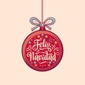 Feliz Navidad. Red Christmas ball with good wishes in Spanish. Royalty Free Stock Photo